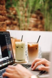 Hands Typing on Laptop with Cocktails with Straws near. Eating Healthy for Writers 101