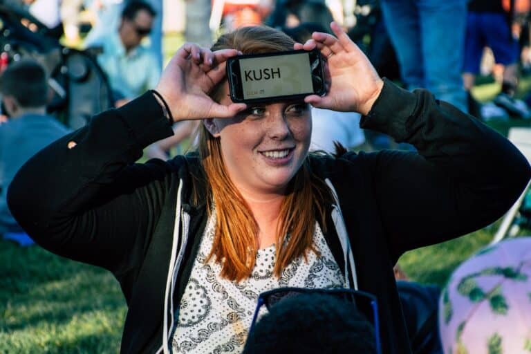 Weekend Word Games Person Holding Android Smartphone Showing Kush Text